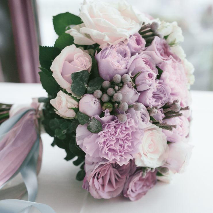 Elegant dusty mauve wedding bridal bouquet with mauve roses and green foliage.