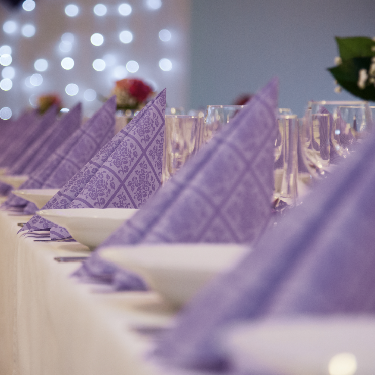 Dusty mauve wedding reception table setting with mauve napkins.