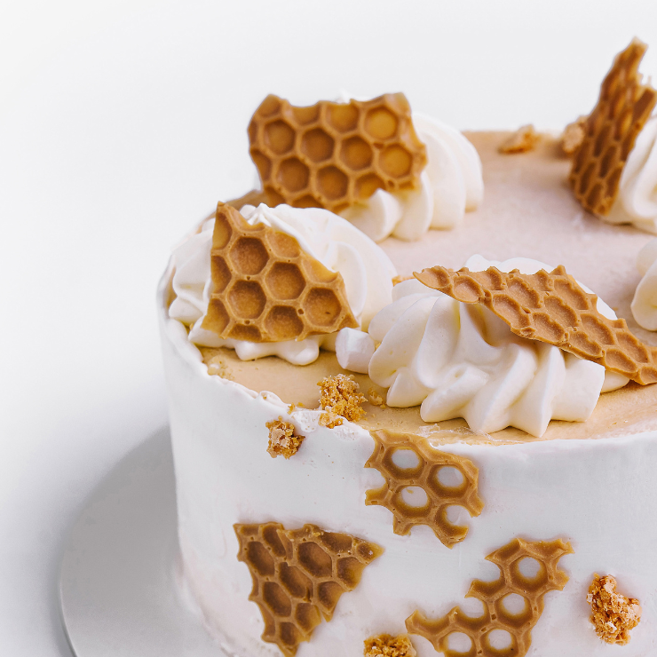 Bride to bee bridal shower cake with honeycomb wafers and white cream.