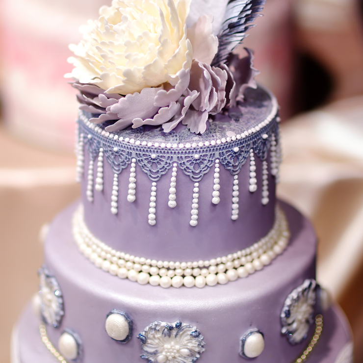 Dusty mauve wedding cake with mauve icing, pearls and peony flower on top.