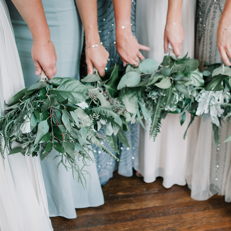 Sage green wedding bridesmaid bouquets with flowing green foliage.