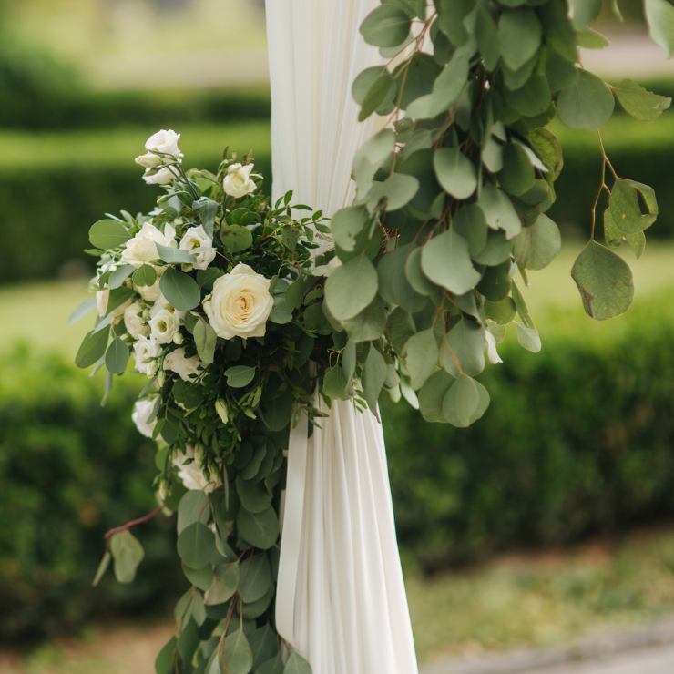 Sage green wedding decor with white roses and eucalyptus leaves.