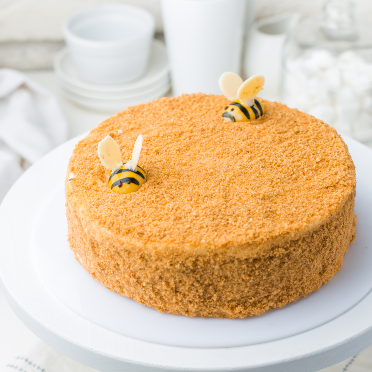 Bride to bee bridal shower cake topped with crumbed biscuits and decorated with honey bees.