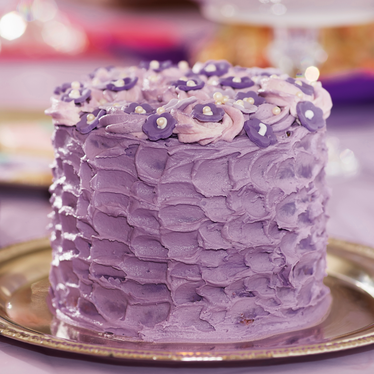 Dusty mauve wedding cake with cream in shades of mauve and swirls with iced flowers and pearl centers.