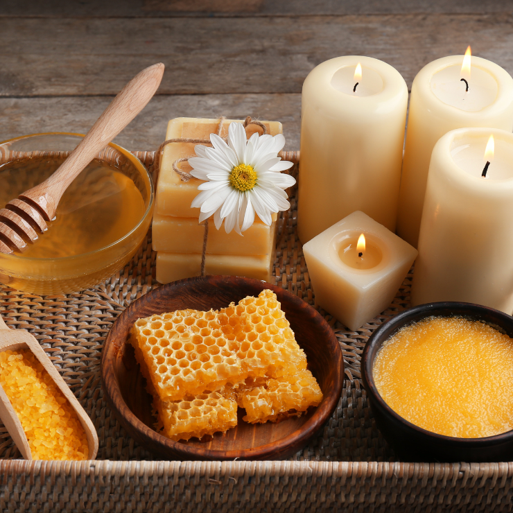 Bride to bee bridal shower decor with beeswax candles, soap, baths salts, honey and honeycomb on a rustic basket weave tray.