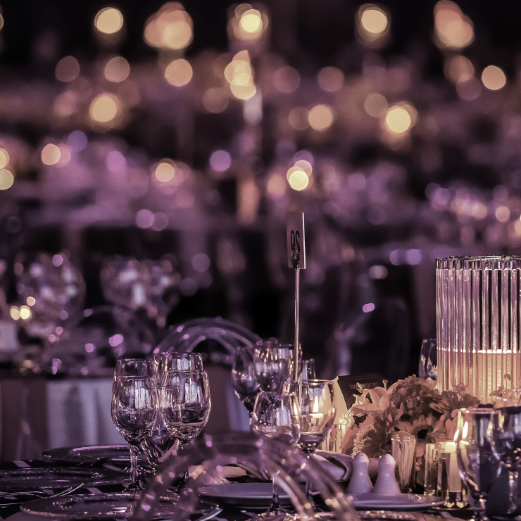 Dusty mauve wedding reception setting with twinkle lights and candles.