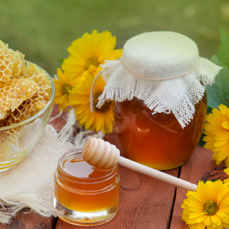 Bride to bee sunflower bridal shower with honey jar, honeycomb and yellow flowers.