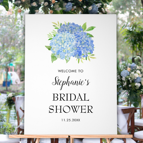 Blue hydrangea bridal shower welcome acrylic sign on easel with modern watercolor blue hydrangea bouquet with foliage and script typography.