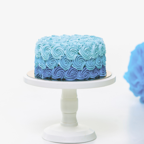 blue hydrangea flower with blue iced cake on white stand