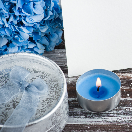 blue hydrangea flowers with blue tealight candle and tin