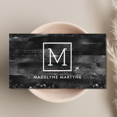 Chic classy black business cards with a glamorous shimmer design and clean white monogrammed logo design in white sans serif typography.