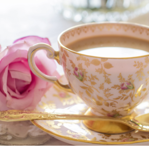 Coquette bridal shower theme inspiration image of vintage gold embellished teacup with pink rose.