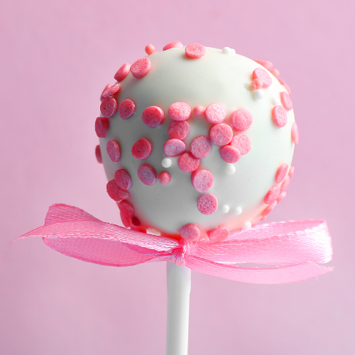 Coquette bridal shower theme inspiration image of a round white candy on a stick with pink round sprinkles and pink silky bow.