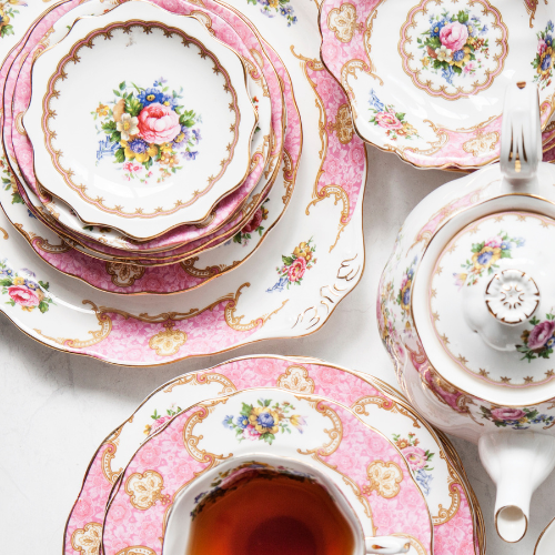 Coquette bridal shower theme inspiration image of vintage teacups and teapot with a flowers and pink pattern.